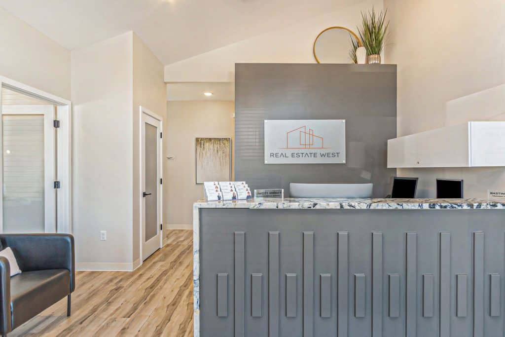 Modern real estate office reception area with sleek design, marble accents, and welcoming atmosphere, showcasing professional West Michigan real estate services.