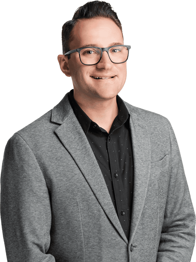 Modern real estate agent in West Michigan wearing a grey blazer and black shirt, representing property sales and home buying expertise.